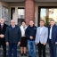 grupa osob stojaca przed budynkiem urzedu gminy